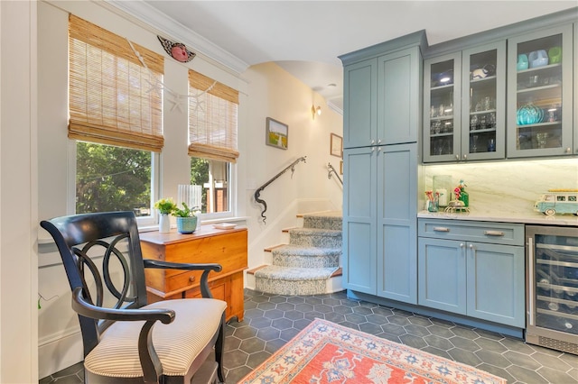 living area with wine cooler, dark tile patterned flooring, a bar, and stairs
