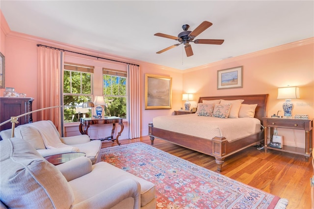 bedroom with crown molding, ceiling fan, visible vents, baseboards, and wood finished floors