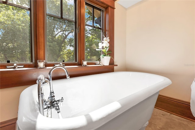 full bathroom featuring baseboards, a freestanding bath, and wood finished floors
