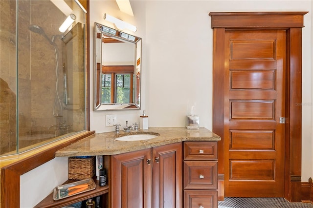 bathroom with tiled shower and vanity