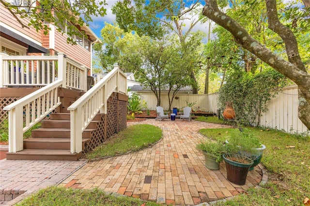view of yard with fence, a patio area, and stairs