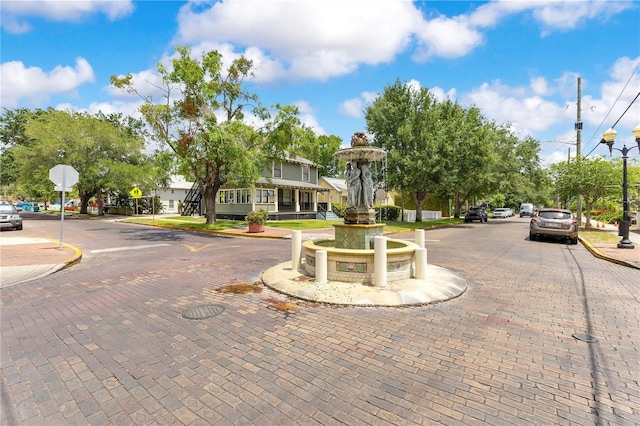 view of road with street lights, curbs, sidewalks, and traffic signs