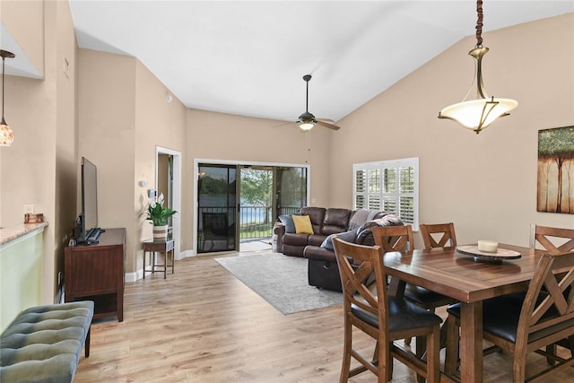 dining space with light wood-type flooring, high vaulted ceiling, ceiling fan, and baseboards