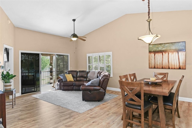 living room with light wood-type flooring, a ceiling fan, high vaulted ceiling, and baseboards
