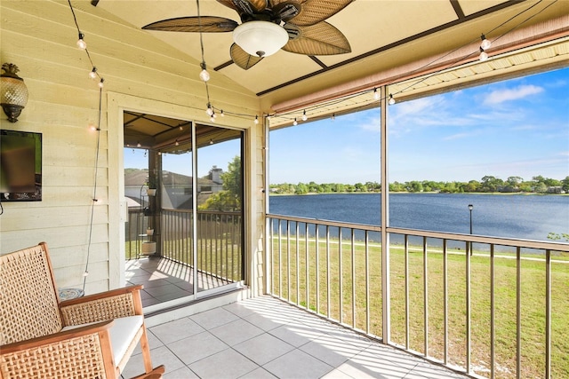 sunroom / solarium featuring a water view and a ceiling fan