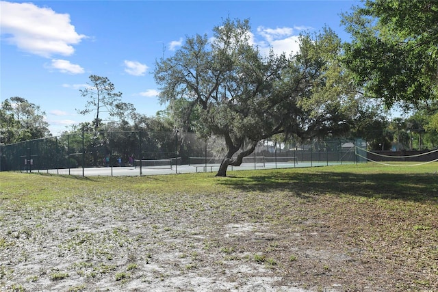 view of yard with a tennis court and fence