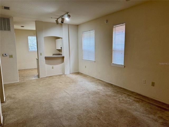 107 Vista Verdi Cir Unit 121, Lake Mary, FL 32746 - spare room with light colored carpet, arched walkways, rail lighting, and baseboards