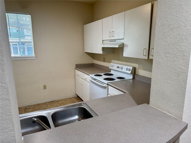 107 Vista Verdi Cir Unit 121, Lake Mary, FL 32746 - kitchen featuring white electric range, under cabinet range hood, white cabinets, and a textured wall