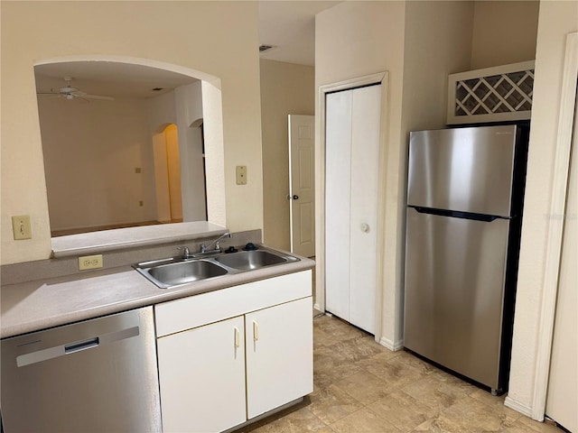 107 Vista Verdi Cir Unit 121, Lake Mary, FL 32746 - kitchen with stainless steel appliances, a sink, a ceiling fan, white cabinetry, and arched walkways