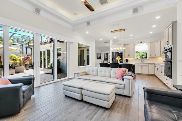 2172 Sherbrook Ave, Davenport, FL 33837 - living area with light wood-style floors, recessed lighting, visible vents, and crown molding