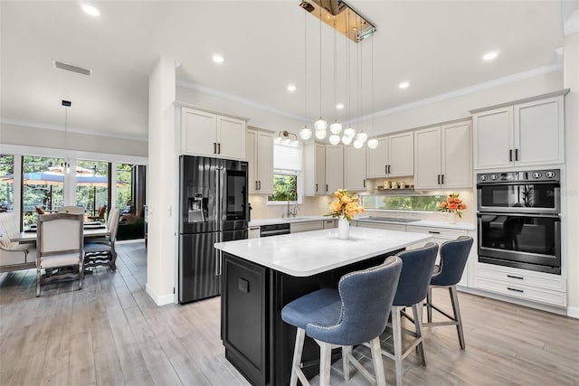 2172 Sherbrook Ave, Davenport, FL 33837 - kitchen with light countertops, crown molding, cooktop, visible vents, and refrigerator with ice dispenser