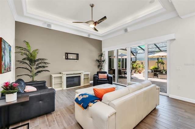 2172 Sherbrook Ave, Davenport, FL 33837 - living area with a raised ceiling, wood finished floors, ceiling fan, and baseboards