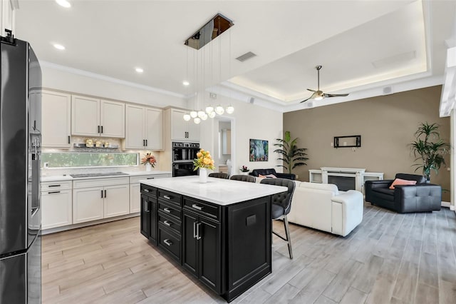 2172 Sherbrook Ave, Davenport, FL 33837 - kitchen featuring dark cabinets, open floor plan, a kitchen bar, a raised ceiling, and black appliances