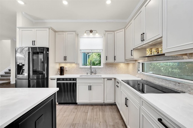 2172 Sherbrook Ave, Davenport, FL 33837 - kitchen with crown molding, stainless steel fridge with ice dispenser, dishwashing machine, white cabinetry, and a sink