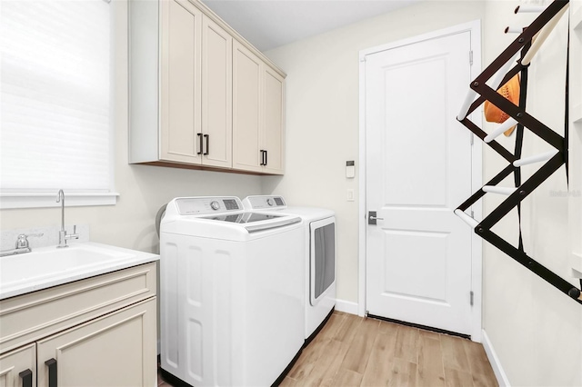 2172 Sherbrook Ave, Davenport, FL 33837 - washroom featuring baseboards, separate washer and dryer, a sink, light wood-style floors, and cabinet space