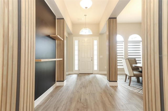 foyer entrance with wood finished floors and baseboards