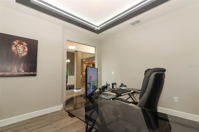 office featuring visible vents, baseboards, a chandelier, and wood finished floors