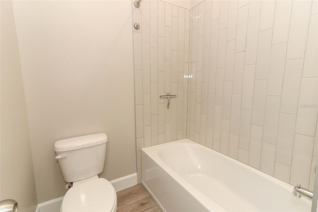 full bathroom featuring bathing tub / shower combination, baseboards, toilet, and wood finished floors
