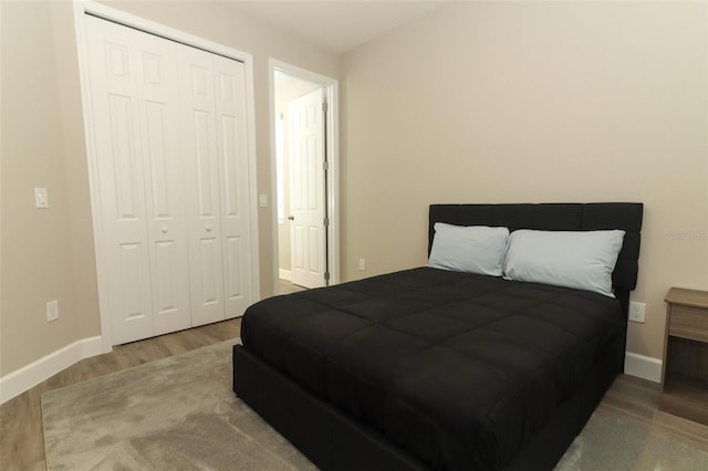 bedroom featuring a closet, baseboards, and wood finished floors