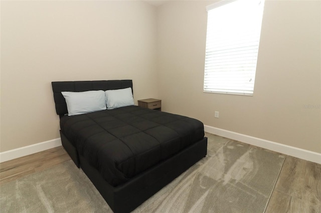 bedroom featuring baseboards and wood finished floors