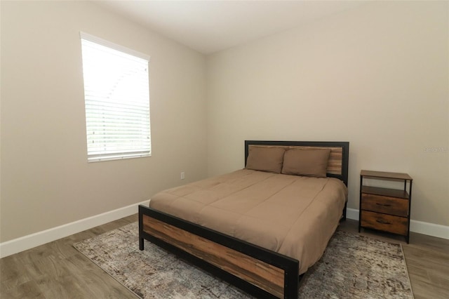 bedroom featuring baseboards and wood finished floors