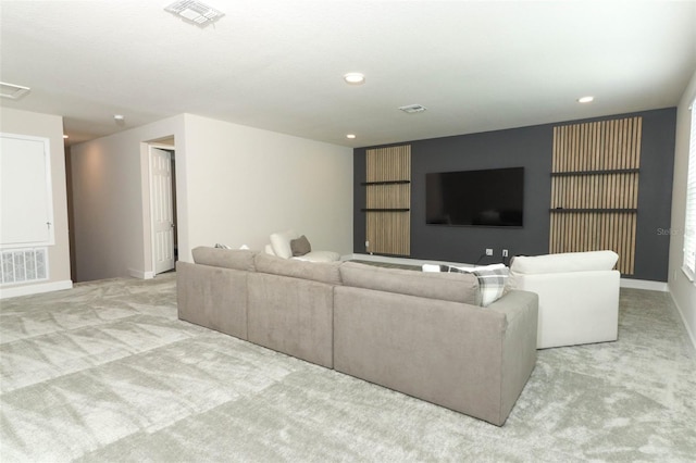 living area featuring visible vents, light colored carpet, and baseboards