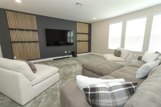carpeted living area featuring baseboards, visible vents, and recessed lighting