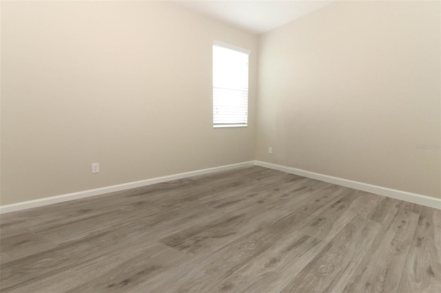 empty room featuring light wood-style flooring and baseboards