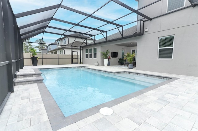 view of swimming pool with a patio area, a fenced in pool, and a lanai