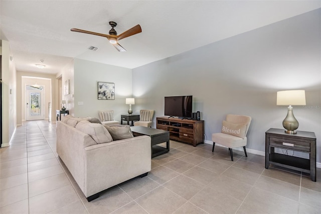 living room featuring light tile patterned floors, baseboards, a ceiling fan, and visible vents