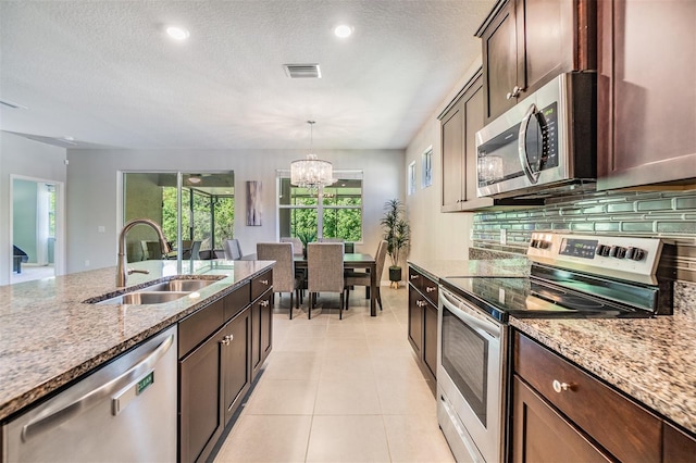 kitchen featuring an inviting chandelier, light tile patterned floors, visible vents, a sink, and stainless steel appliances