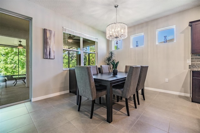 dining room featuring light tile patterned floors, baseboards, and ceiling fan with notable chandelier