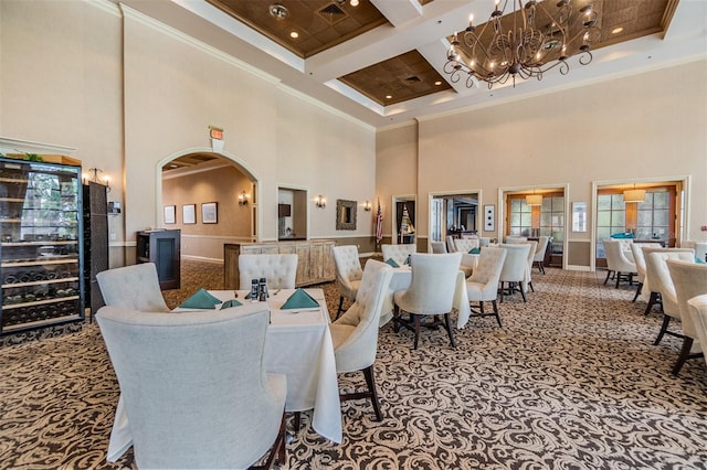 dining space with arched walkways, a high ceiling, an inviting chandelier, crown molding, and coffered ceiling