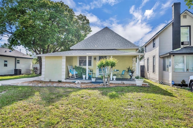 1110 Virginia Ave, Saint Cloud, FL 34769 - rear view of property with roof with shingles, stucco siding, central AC unit, a porch, and a yard