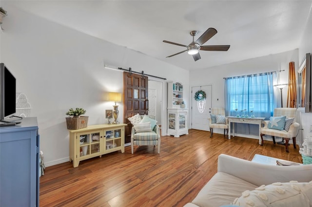 1110 Virginia Ave, Saint Cloud, FL 34769 - living area featuring wood finished floors, baseboards, a ceiling fan, and a barn door