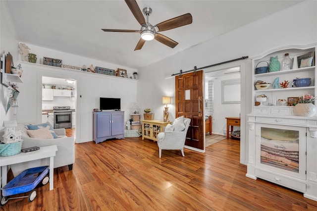 1110 Virginia Ave, Saint Cloud, FL 34769 - living room featuring light wood-style flooring, a ceiling fan, and a barn door