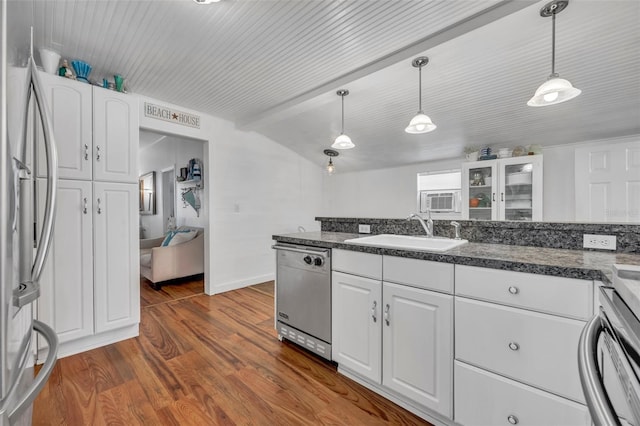 1110 Virginia Ave, Saint Cloud, FL 34769 - kitchen with white cabinets, a sink, dark countertops, dark wood-style floors, and stainless steel appliances