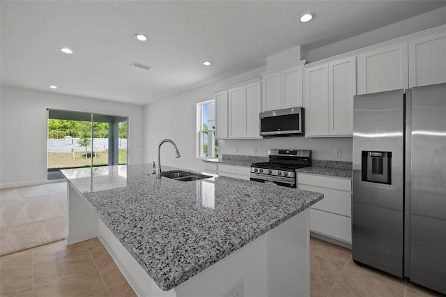 kitchen featuring a sink, a wealth of natural light, white cabinets, and stainless steel appliances