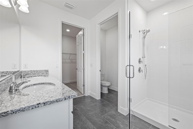 full bathroom featuring visible vents, a sink, toilet, a walk in closet, and a stall shower