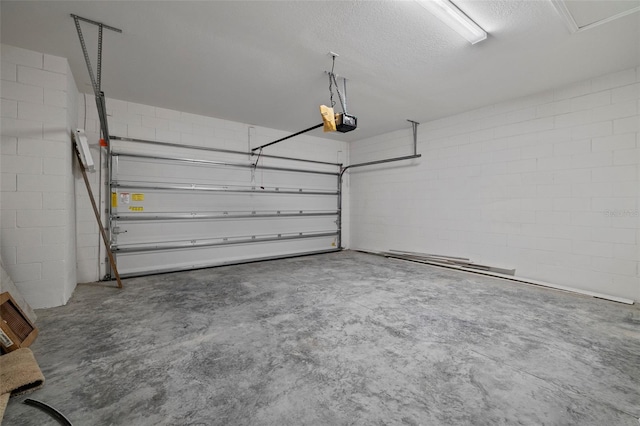 garage featuring a garage door opener and concrete block wall