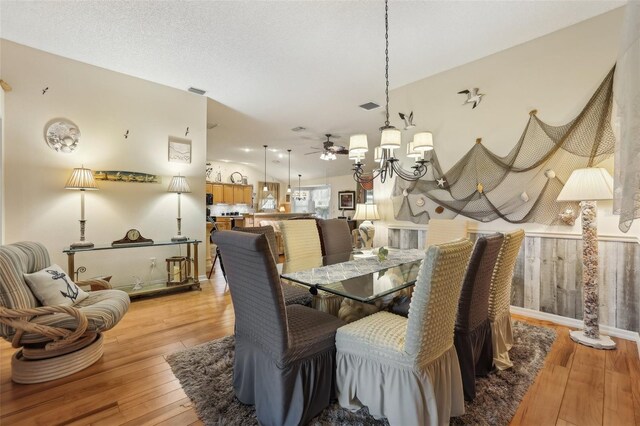 433 Arcadia Lakes Dr, The Villages, FL 32162 - dining space featuring light wood-style flooring, a textured ceiling, visible vents, and ceiling fan with notable chandelier