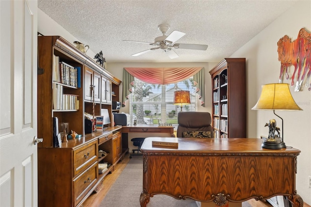433 Arcadia Lakes Dr, The Villages, FL 32162 - home office featuring light wood-style floors, a textured ceiling, and a ceiling fan