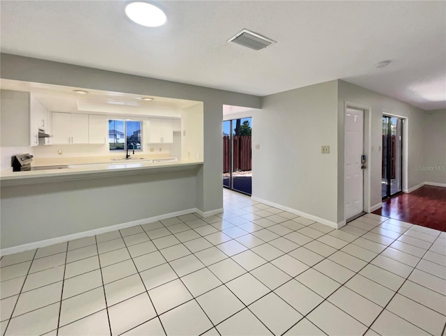 interior space featuring stainless steel electric range oven, visible vents, light countertops, and light tile patterned floors