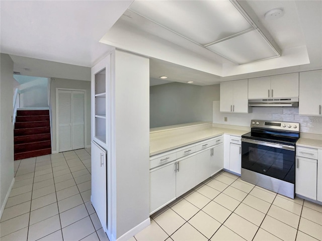 kitchen with light countertops, under cabinet range hood, stainless steel electric range, decorative backsplash, and light tile patterned flooring