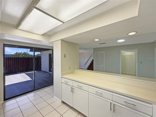 kitchen with light countertops, white cabinetry, light tile patterned flooring, and recessed lighting
