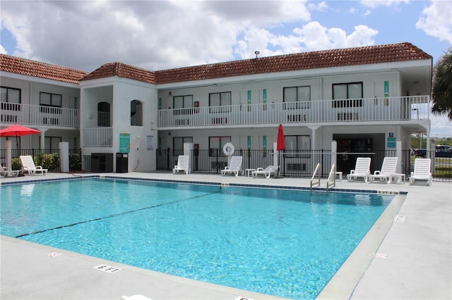 community pool featuring a patio area and fence