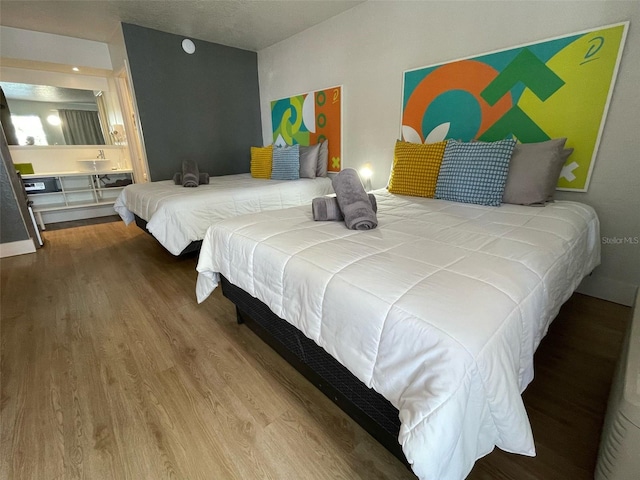 bedroom featuring connected bathroom and wood finished floors