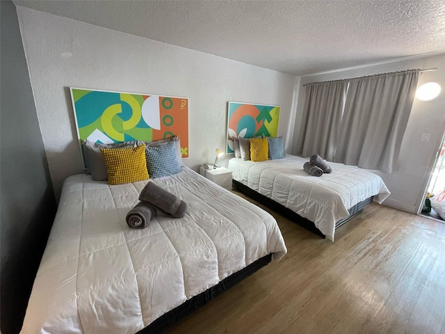 bedroom featuring wood finished floors and a textured ceiling