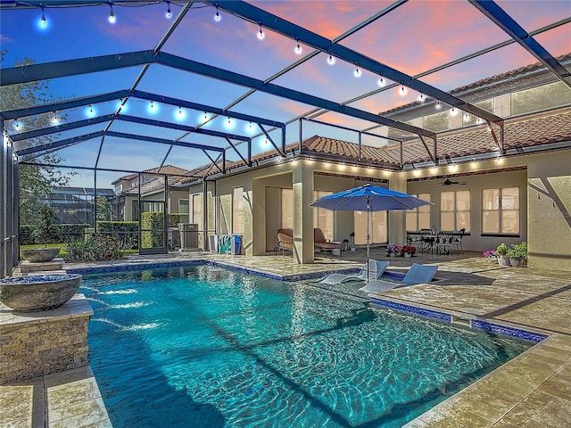 outdoor pool with a patio area and glass enclosure