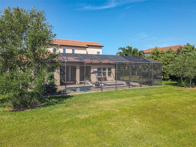 rear view of house with a tiled roof, a lawn, a patio, stucco siding, and an outdoor pool